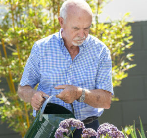 Eldery resident watering the gardens at The Richardson